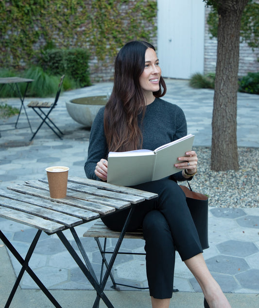 girl sitting on a chair reading her flow journal